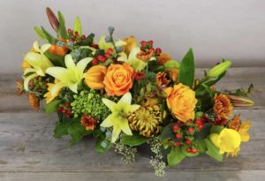 orange roses and white lilies and assorted fall colored florals