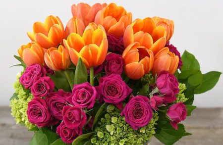 Orange tulips in vase with dark pink roses