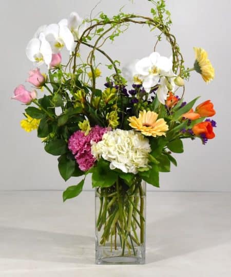Treat someone to a cheerful palette of floral bliss with tulips, roses, hydrangea, stock and more in stylish glass vase bringing a splash of spring color to any space!