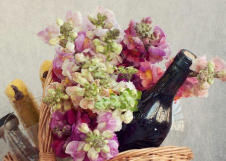 basket of flowers and a bottle of wine